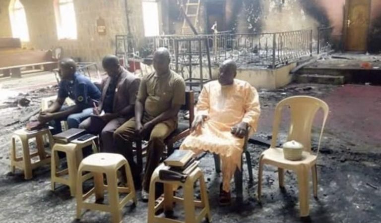 Les anciens tiennent un service dans le bâtiment de l’église incendiée après l’attaque de Boko Haram