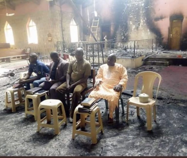 Les anciens tiennent un service dans le bâtiment de l’église incendiée après l’attaque de Boko Haram